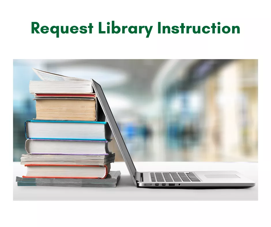 An open laptop is sitting with its screen propped on a stack of books